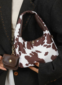 petit sac a main avec petite sacoche style tache animal marron fonce portee style femme elegante tenu par la main