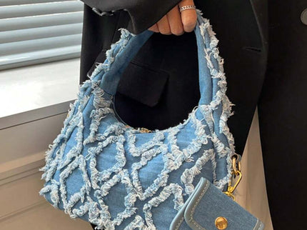 sac bleu brodee effilochee en jeans tenu par la main