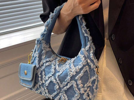 sac bleu brodee effilochee en jeans tenu par la main droite femme elegante
