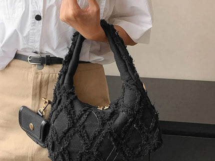 sac noir style effilochee brodee femme portant main gauche