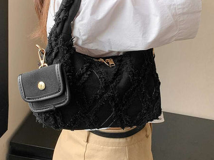 sac noir style effilochee brodee femme portant sur l'epaule droite