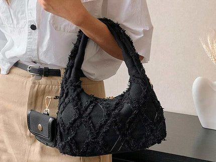 sac noir style effilochee brodee femme portant sur l'epaule droite et main droite 