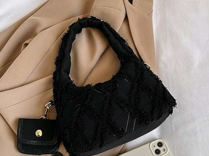 sac noir style effilochee brodee pose sur manteau style affaire